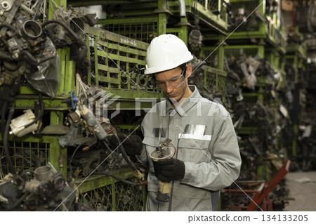 Technician worker working and checking in garage scrap yard car workshop warehouse. Technician worker working and checking in garage scrap yard car workshop warehouse. 134133205