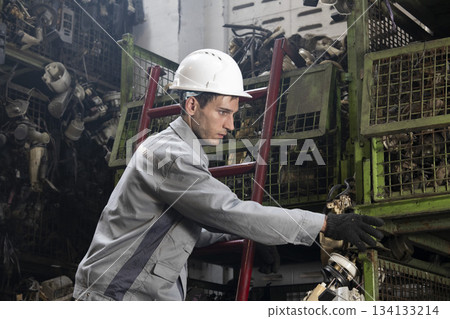 Technician worker working and checking in garage scrap yard car workshop warehouse. 134133214