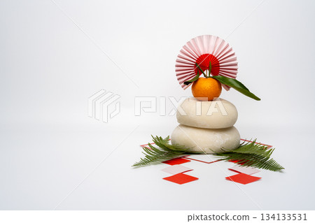 A photo of a real rice cake, "Kagami Mochi," placed on the right, on a white background, without a pedestal. A photo of a real rice cake, "Kagami Mochi," placed on the right, on a white background, without a pedestal. 134133531