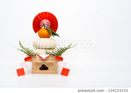 A photo of "Kagami mochi" (real rice cake) placed on the left, on a white background, with a low sanpo (pedestal). 134133533