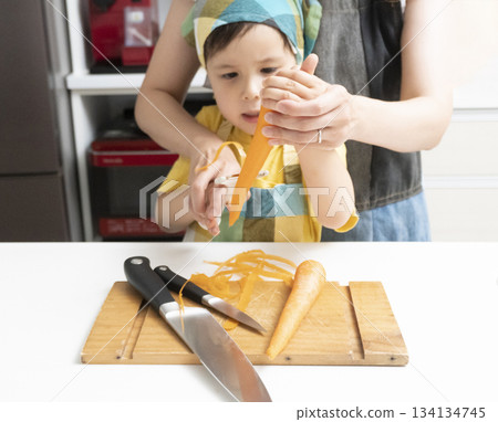 母親和兒子在廚房裡一起削胡蘿蔔 134134745