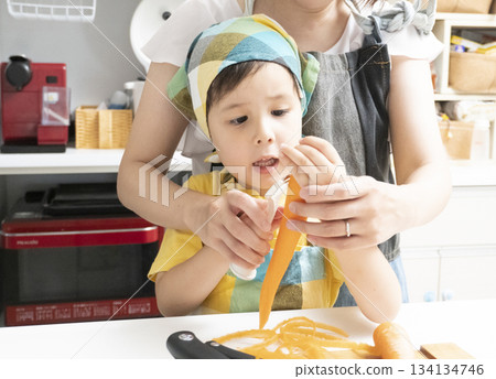 母親和兒子在廚房裡一起削胡蘿蔔 134134746