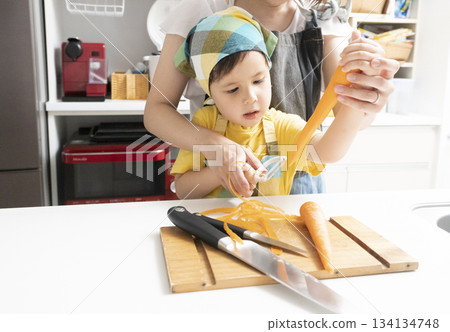母親和兒子在廚房裡一起削胡蘿蔔 134134748