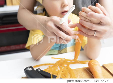 母親和兒子在廚房裡一起削胡蘿蔔 134134750