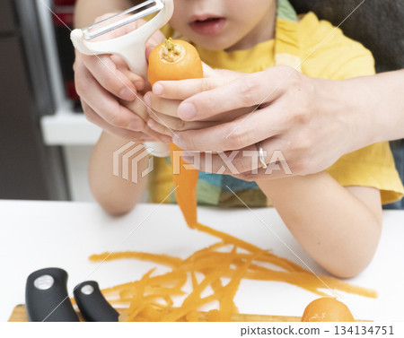 母親和兒子在廚房裡一起削胡蘿蔔 134134751