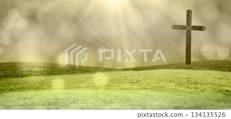 Solitary wooden cross is standing on green rolling hills in flat design with soft sun rays Solitary wooden cross is standing on green rolling hills in flat design with soft sun rays 134135526