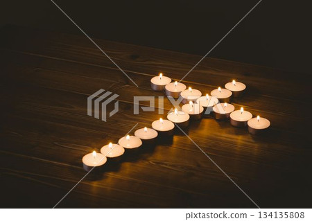 Burning candles in shape of cross 134135808