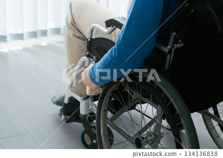 Man in a wheelchair using a laptop Man in a wheelchair using a laptop 134136838