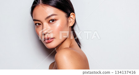 Model poses against a plain background showcasing natural beauty and simplicity in a fresh, clean look 134137416