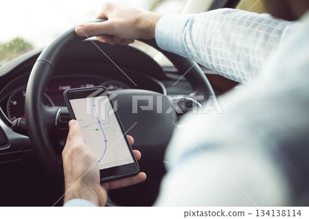 Man driver using smart phone in car Man driver using smart phone in car 134138114