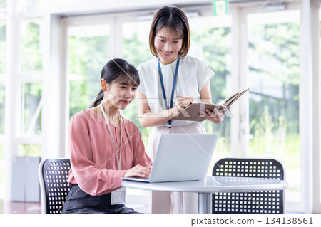 一位職業婦女正在開會，同時看著電腦。 134138561