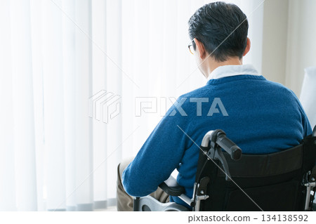 Middle-aged man in a wheelchair Middle-aged man in a wheelchair 134138592