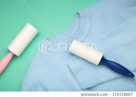 Lint roller on blue texture background to remove pet animal hair. Lint roller on blue texture background to remove pet animal hair. 134138667