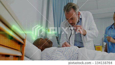 Leaning doctor listening to patient chest under patterned gown at hospital bed, with stethoscope Leaning doctor listening to patient chest under patterned gown at hospital bed, with stethoscope 134138764