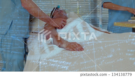 Staff in scrubs doing chest compressions on hospital bed, preparing supplies tray with oxygen mask 134138779