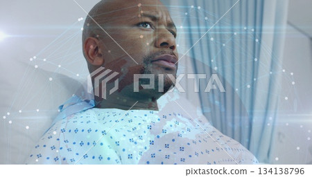 Reclining male patient wearing medical gown gazing in hospital ward, with digital network overlay Reclining male patient wearing medical gown gazing in hospital ward, with digital network overlay 134138796