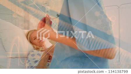 Nurse in scrubs aligning IV bag beside patient in hospital gown on bed in hospital room Nurse in scrubs aligning IV bag beside patient in hospital gown on bed in hospital room 134138799