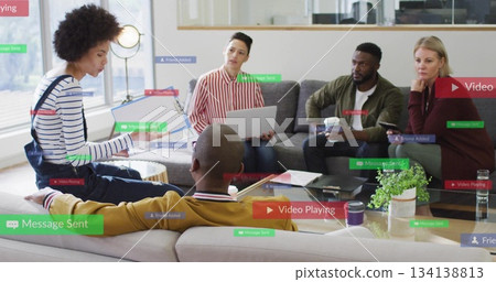 Colleagues discussing ideas in office lounge with laptop, smartphone, digital notifications Colleagues discussing ideas in office lounge with laptop, smartphone, digital notifications 134138813