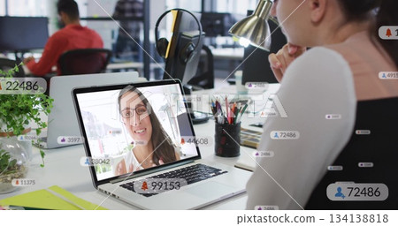 Leaning office worker wearing vest joining remote meeting at open office with laptop, copy space 134138818