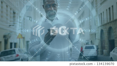 Walking African American man holding smartphone on city street, with 6G overlay and parked cars 134139070