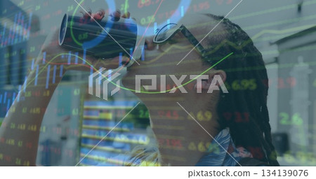 Drinking sunglassed man sipping from tumbler in office, with stock graphs overlay, copy space 134139076