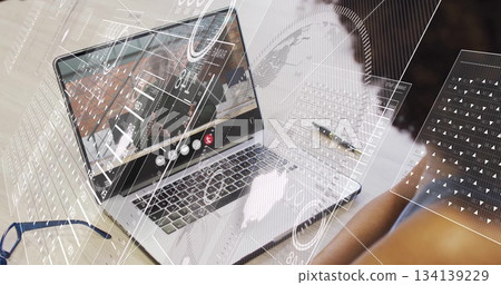 Showing silver laptop hosting conference at home desk, with eyeglasses smartphone notebook pen 134139229