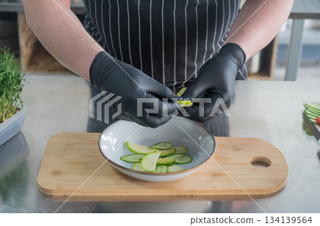 The chef lays out the salad.  134139564