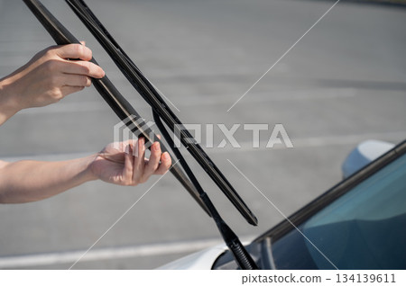 Close up of female hands changing windshield wipers.  134139611