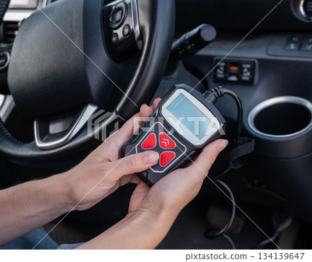 Woman using OBD2 diagnostic scanner.  134139647