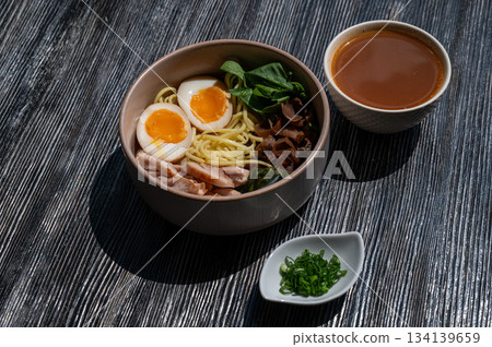 Ramen soup in a cafe. Broth separately.  134139659