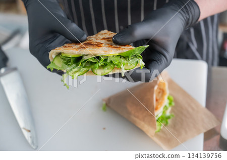 Chef holding a flatbread with herbs. Chef holding a flatbread with herbs. 134139756
