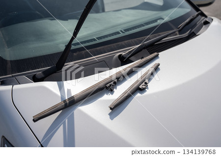 Windscreen wipers lying on the hood. Seasonal replacement.  134139768
