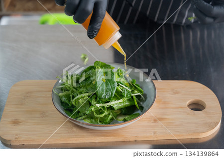 The chef prepares a salad. The chef prepares a salad. 134139864