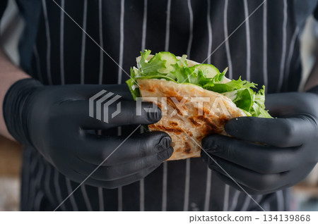 Chef holding a flatbread with herbs. Chef holding a flatbread with herbs. 134139868