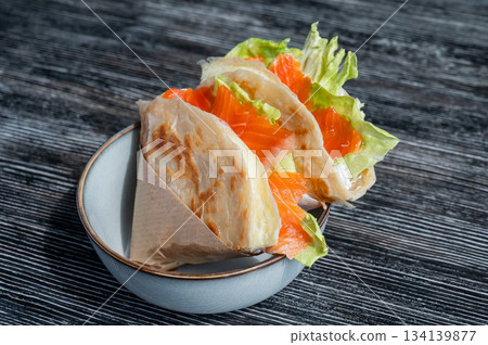 Homemade salmon flatbread on a table in a cafe. Homemade salmon flatbread on a table in a cafe. 134139877