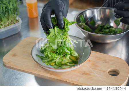 The chef prepares a salad. The chef prepares a salad. 134139944
