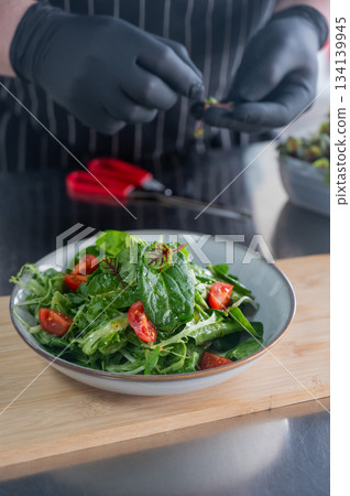The chef prepares a salad. The chef prepares a salad. 134139945