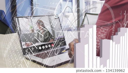 Reviewing analytics overlays, man in red sweater using laptop, pen and notebook at office desk 134139962