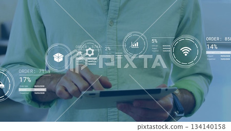 Man wearing green shirt tapping tablet in office with order tracking icons, IDs and percentages Man wearing green shirt tapping tablet in office with order tracking icons, IDs and percentages 134140158
