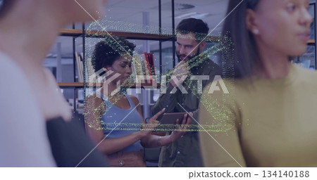Pointing woman wearing blue top showing tablet to white man in office library, with bookshelves Pointing woman wearing blue top showing tablet to white man in office library, with bookshelves 134140188