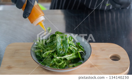 The chef prepares a salad. The chef prepares a salad. 134140230