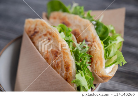 Flatbread with greens served in a cafe. Flatbread with greens served in a cafe. 134140260