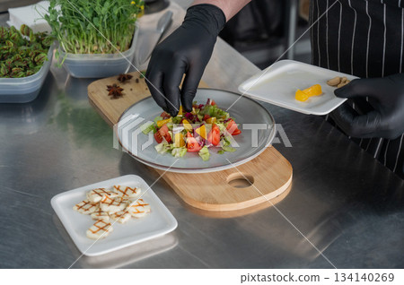 The chef lays out the salad. The chef lays out the salad. 134140269