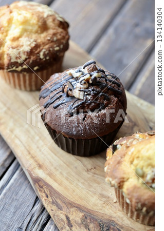Three types of muffins arranged on a wooden board Three types of muffins arranged on a wooden board 134140304