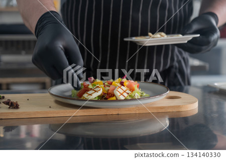 The chef lays out the salad. The chef lays out the salad. 134140330