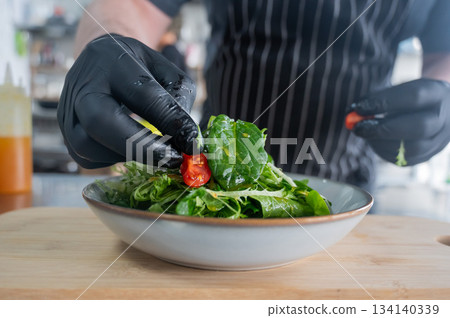 The chef prepares a salad.  134140339