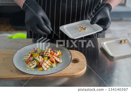 The chef lays out the salad. The chef lays out the salad. 134140397