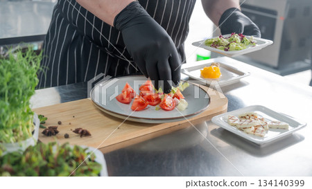 The chef lays out the salad.  134140399