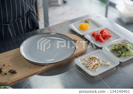 The chef lays out the salad.  134140401