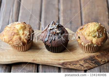 Three types of muffins arranged on a wooden board Three types of muffins arranged on a wooden board 134140406